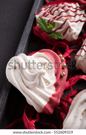Homemade meringues in heart shape in old wooden box for Valentine's day, top view, copy space.