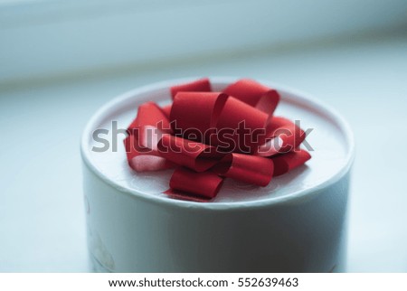 The gift on the table, , white box with a red ribbon, holiday, top view