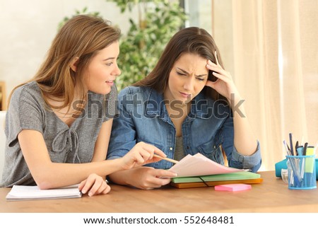 Student studying and teaching to her classmate in the living room at home Royalty-Free Stock Photo #552648481