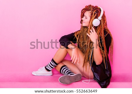 Pretty young girl listening to the music and smiling
