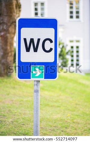  WC or toilet sign with white house in background