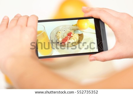 Female hands photographing food with mobile phone