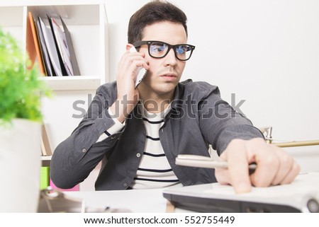 businessman freelance speaking by cellphone at home or office with laptop computer