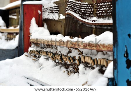 Vintage Piano musical instrument under the snow