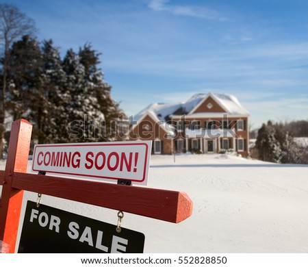 For Sale and Coming Soon realtor sign in front of large brick single family house in expansive snow cover yard in mid winter