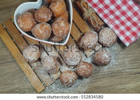 Sweet donuts in a dish in the shape of heart. Fat Thursday Slavic culture 