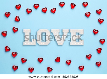 Plain blue background with frame made of little, red hearts and white love inside of it