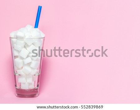 Glass full of sugar cubes - unhealthy diet concept. Royalty-Free Stock Photo #552839869