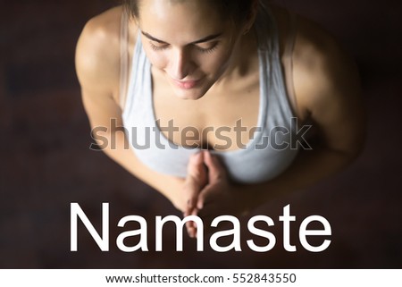 Close up portrait of beautiful young happy fit woman doing yoga or pilates exercise. Fitness motivation quote with motivational text "Namaste". Healthy lifestyle concept. Tadasana pose with Namaste