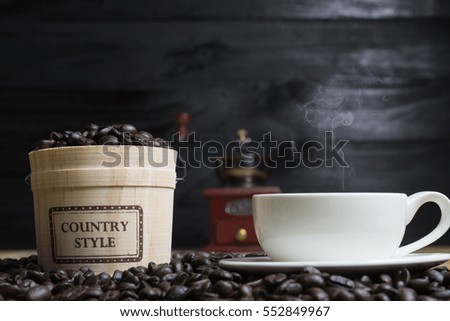 Coffee cup and Coffee beans with casks on wood background