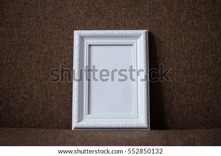  white photo frame on brown couch