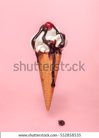 melting ice cream cone with chocolate syrup and cranberry isolated on pink background 