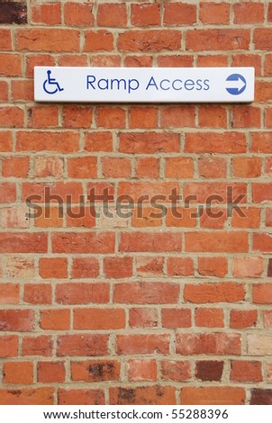 ramp access sign on a brick wall background