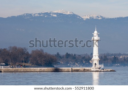 Lighthouse at Lake Geneva in the mountains in the background, tourists photograph
