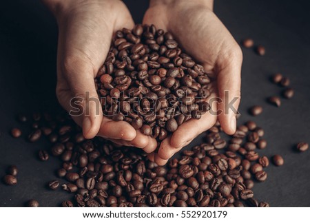 coffee beans, black background, coffee beans in hand