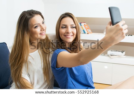 Friends taking a selfie at home.