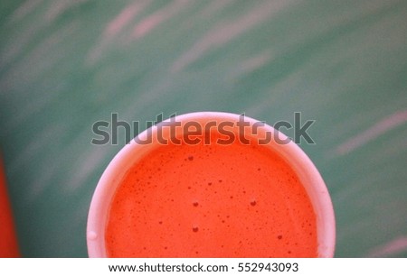 a glass of fresh carrot juice on the green background
