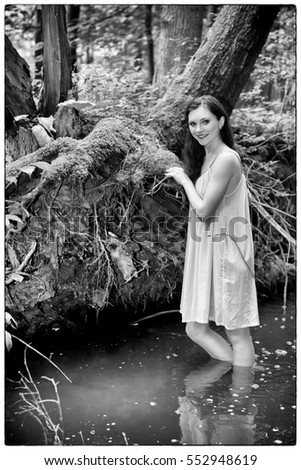 Beautiful girl in a forest near the creek - like a water nymph conjure and bathed in water