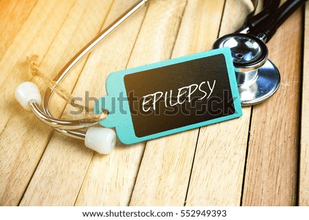 Wooden tag written with EPILEPSY and stethoscope on wooden background. Medical and Healthcare Concept.