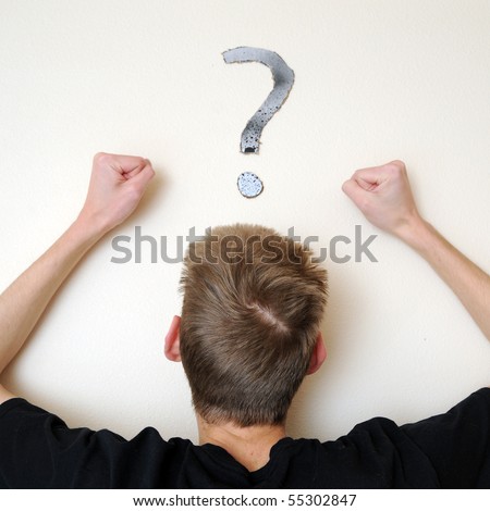 Young white Caucasian male adult staring forward, confused, with a question mark above his head on the wall. Focus point is on the person's head.