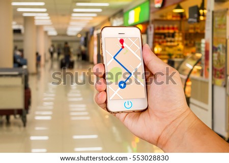 Man is holding mobile phone with map gps navigation in the airport.