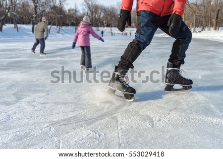 Close-up of ice skater braking on ice rink
