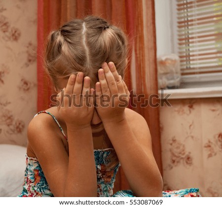 little girl with pigtails, which put her hands her face. / Little girl hiding her face