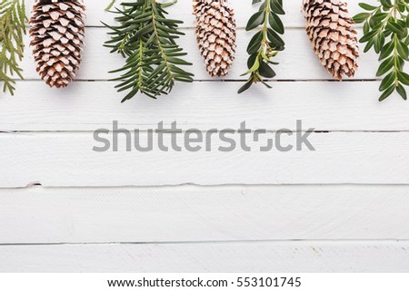 White wood Christmas border with snow covered pinecones