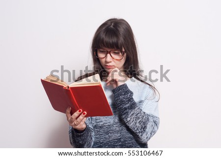 Pretty young girl with red book in glasses isolated