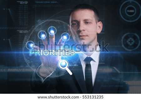 Business, Technology, Internet and network concept. Young businessman working on a virtual screen of the future and sees the inscription: priorities