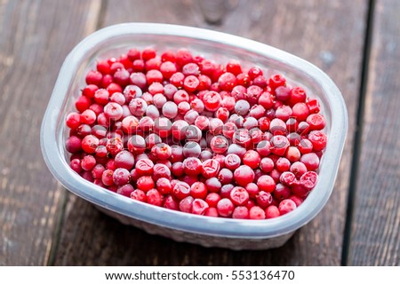 Frozen Cranberries in Container on Wooden Table, Horizontal View