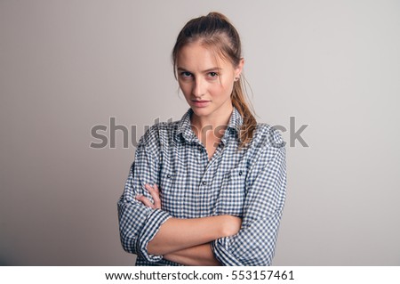 Portrait of frustrated and angry woman on grey background