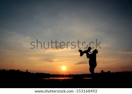 Family concept, Silhouette of father throwing son into the sky. , father and son at lake with sunset background