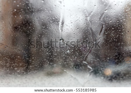 Drops Of Rain On Glass Background. Street Bokeh Lights Out Of Focus. Abstract Backdrop