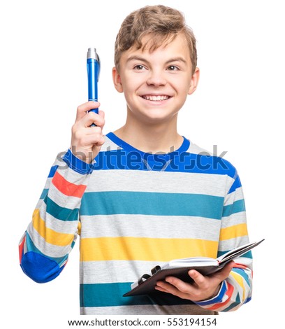 Portrait of caucasian smiling teen boy with notebook and blue pen writing something. Handsome funny teenager, isolated on white background. Happy student making idea gesture. 