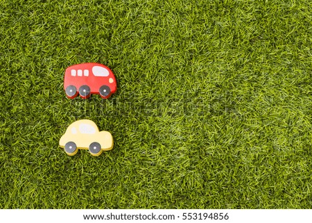 Wooden toy car with text eco car on grass. Transport and ecology concept.
