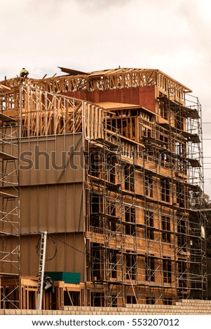Men in hardhats and safety vests working on a large construction project on a cloudy winter day. Laguna Niguel, California
