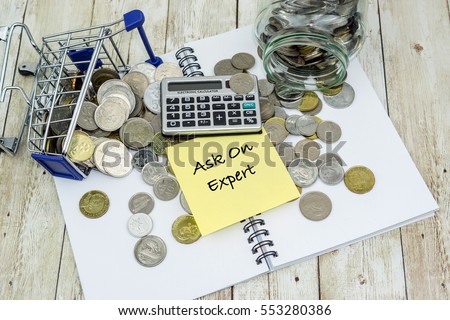 Shopping chart, coins, calculator and ASK ON EXPERT wording on wooden table. Communication concept