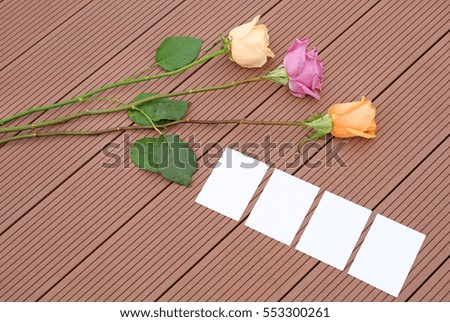 Empty notepaper with rose flower on wooden.