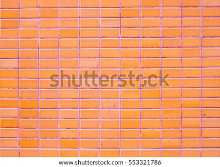 Wall orange glazed tiles in a Thai temple.
