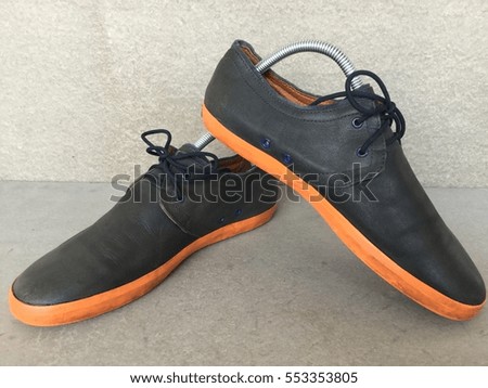 close up vintage style of  black leather sneaker shoes on gray background