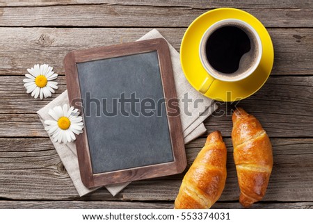 Blackboard, croissants, flowers and coffee cup. Top view with copy space