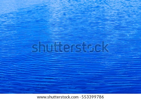 Texture, background, pattern. the water in the pool. Ripple of water in the pool with the sun's reflection. The blue water swimming pool with sun reflections