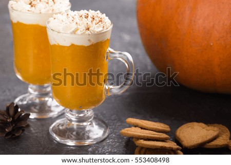 Pumpkin spiced latte or smoothie with whipped cream in glass Autumn or winter hot drink
