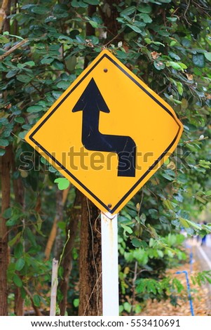 Winding road sign in the forest and mountain