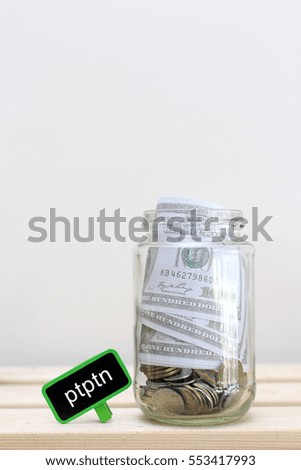 Money jar with coins on wood table , Saving Concept. ptptn