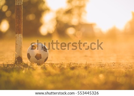 A ball on the grass in the morning sunshine day. Picture for soccer football and sport concept. Film tone picture style.