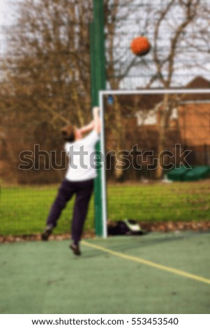 Child practicing playing basketball in a local park Out of focus.