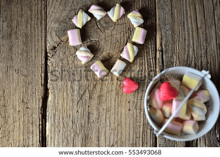 Marshmallow in the form of heart on Valentine's Day on a dark wooden background