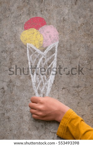 Ice cream drawing with color chalk on concrete wall. Children's doodle.
Creative outdoors playing in summer. Family, happy childhood, kids concept.
